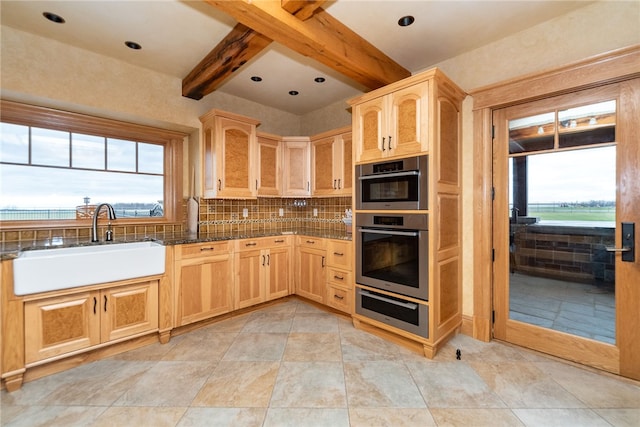 kitchen with backsplash, sink, light brown cabinets, and beam ceiling