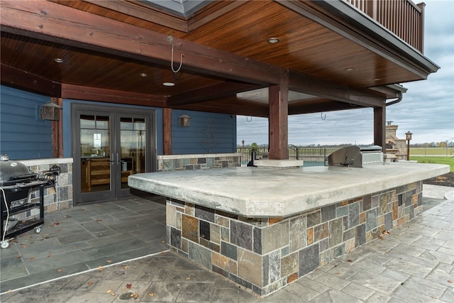 view of patio featuring grilling area, an outdoor kitchen, and french doors