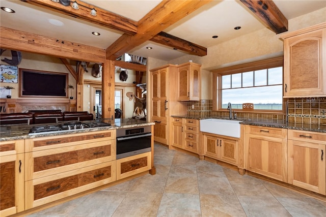 kitchen featuring stainless steel appliances, sink, light brown cabinets, and decorative backsplash