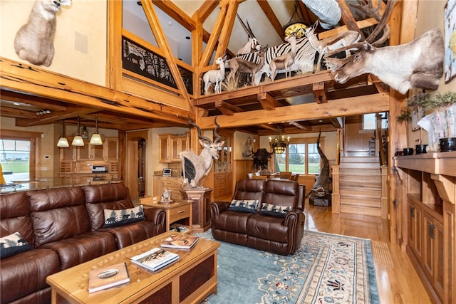 living room with an inviting chandelier, beamed ceiling, wood-type flooring, and high vaulted ceiling