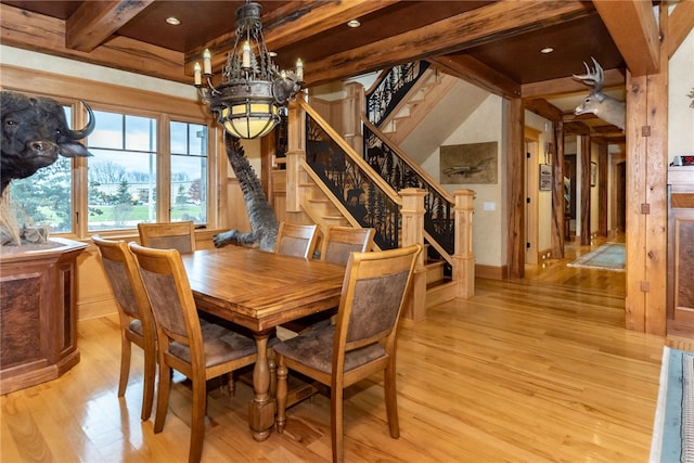 dining room with light wood-type flooring, beamed ceiling, and a notable chandelier