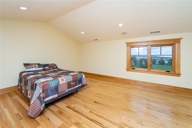 bedroom featuring light wood-type flooring and vaulted ceiling