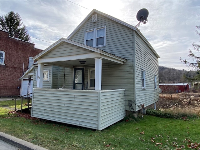 view of front of home with covered porch, a garage, and a front yard