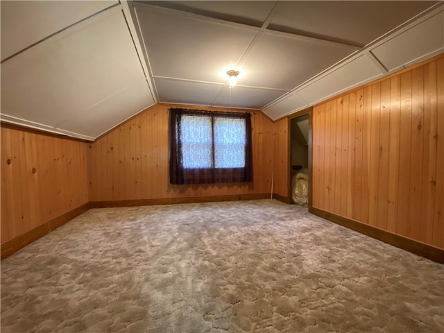 bonus room featuring carpet floors, lofted ceiling, and wooden walls