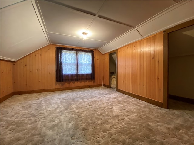 bonus room featuring carpet flooring, wood walls, and lofted ceiling