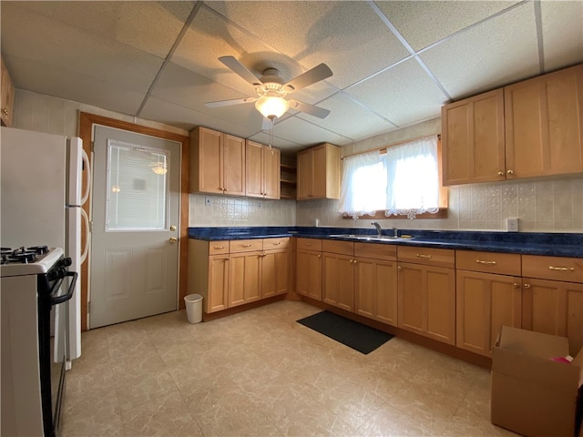 kitchen with a drop ceiling, light tile patterned floors, ceiling fan, gas range, and decorative backsplash