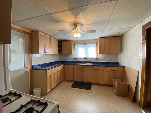 kitchen featuring a drop ceiling, light tile patterned flooring, ceiling fan, and stove