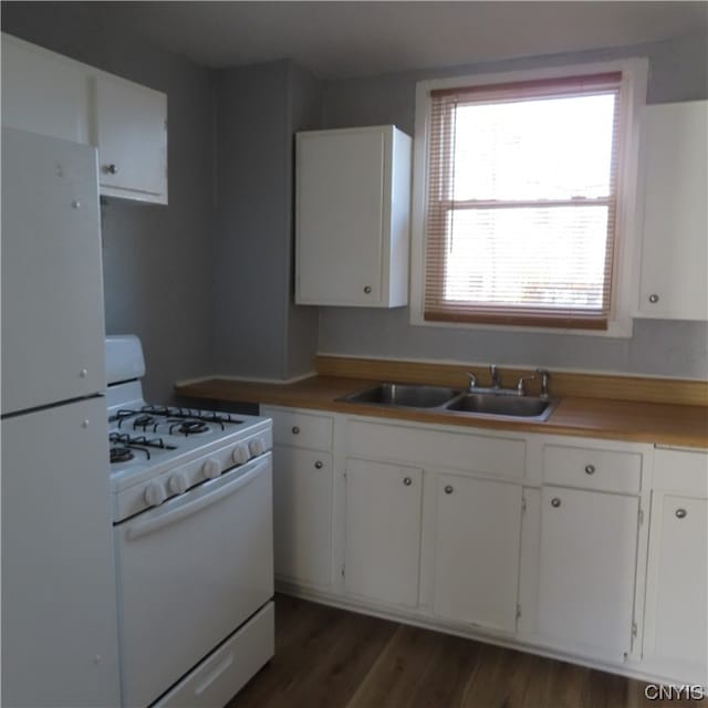 kitchen with plenty of natural light, white cabinetry, and white appliances