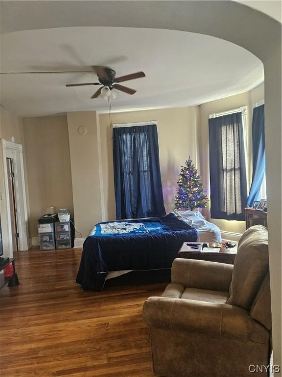 301 E Manlius St, Dewitt, NY 13057 - bedroom featuring wood finished floors, arched walkways, and a ceiling fan