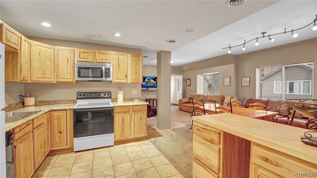 kitchen featuring dishwasher, wooden counters, white electric stove, light carpet, and light brown cabinetry