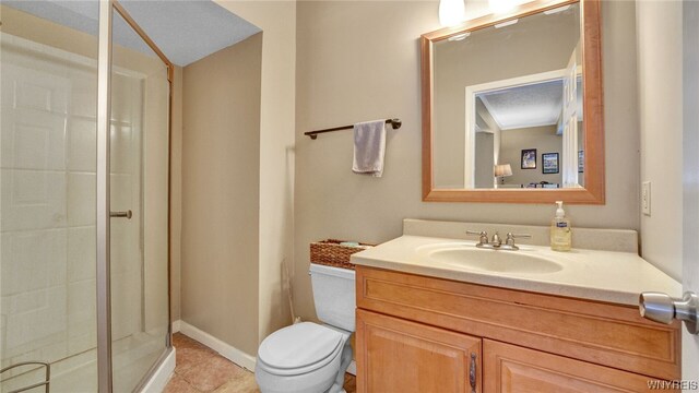 bathroom with toilet, vanity, tile patterned floors, and a shower with shower door