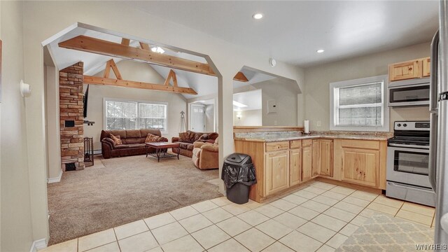 kitchen with lofted ceiling with beams, light brown cabinets, light carpet, and stainless steel appliances