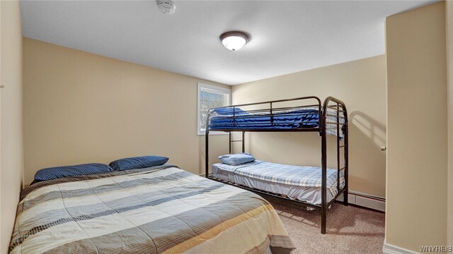 carpeted bedroom with a baseboard heating unit