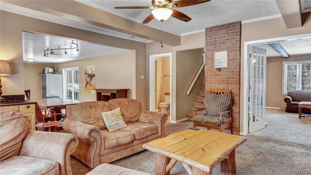 living room with beam ceiling, light carpet, ceiling fan, and ornamental molding