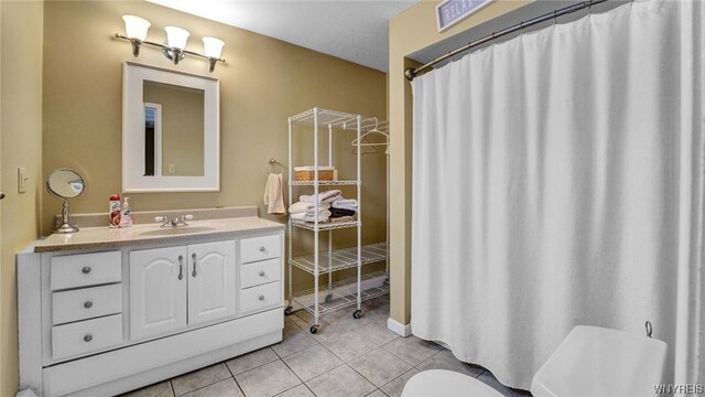 bathroom featuring tile patterned floors, vanity, and toilet