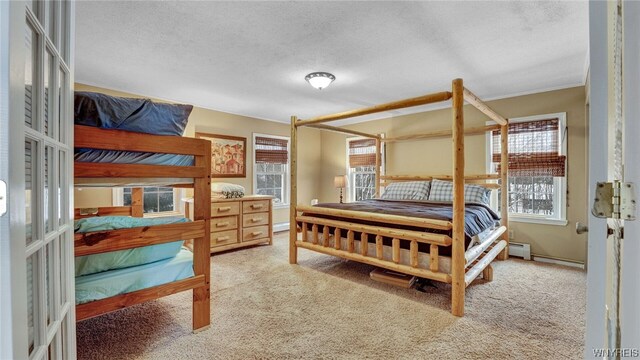 carpeted bedroom featuring baseboard heating and a textured ceiling