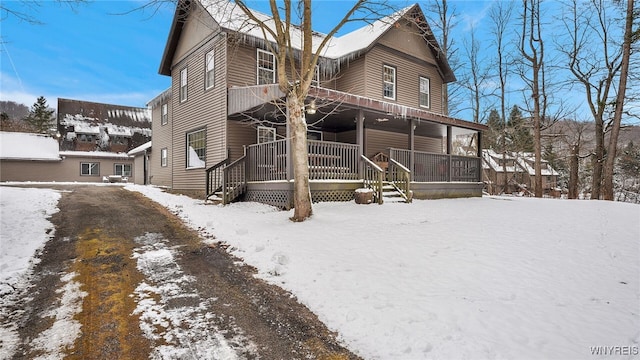 snow covered house featuring a porch