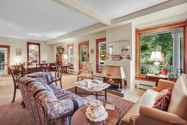 carpeted living room with beamed ceiling and a baseboard radiator