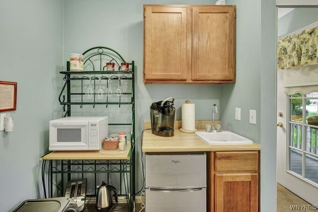 kitchen featuring stainless steel fridge, carpet floors, and sink