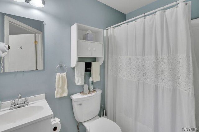 bathroom with a shower with curtain, vanity, and toilet