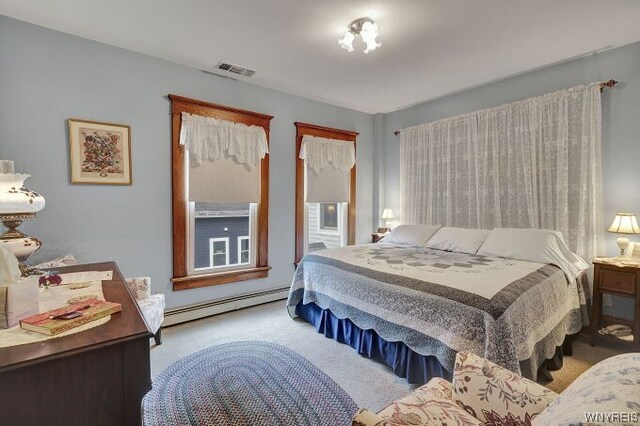 bedroom featuring light colored carpet and a baseboard heating unit