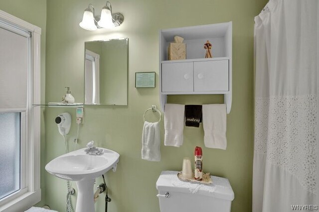 bathroom featuring a shower with shower curtain and toilet