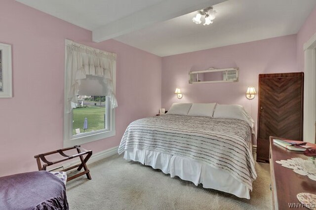 carpeted bedroom featuring beam ceiling