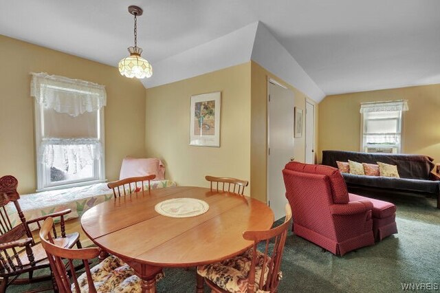 dining space featuring carpet flooring and lofted ceiling