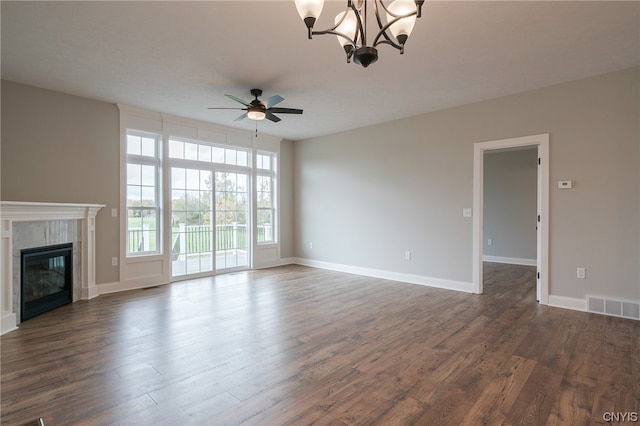 unfurnished living room with ceiling fan with notable chandelier and dark hardwood / wood-style floors