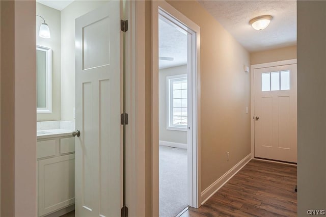 hallway with dark wood-type flooring and a textured ceiling