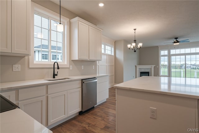 kitchen featuring ceiling fan with notable chandelier, dishwasher, white cabinetry, sink, and hanging light fixtures