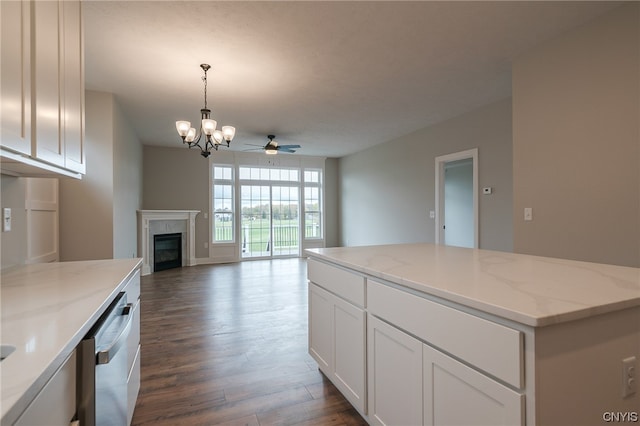 kitchen with decorative light fixtures, dishwasher, light stone countertops, ceiling fan with notable chandelier, and white cabinets