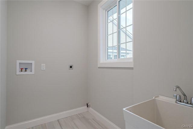 clothes washing area with a wealth of natural light, hookup for an electric dryer, hookup for a washing machine, and sink