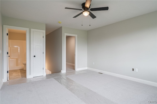 unfurnished bedroom featuring ceiling fan and ensuite bath