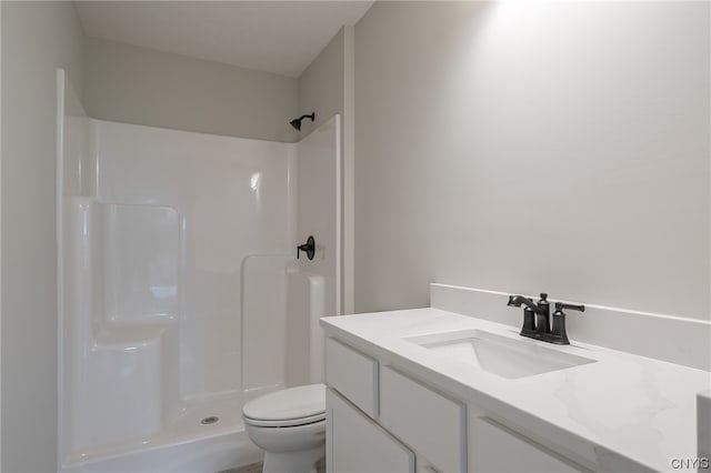 bathroom featuring walk in shower, vanity, and toilet