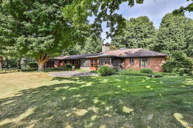 ranch-style house featuring a sunroom and a front lawn