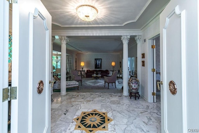 foyer entrance with decorative columns and ornamental molding