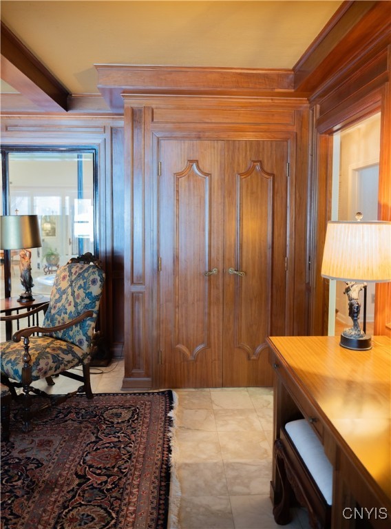 entrance foyer with crown molding, wood walls, and beamed ceiling