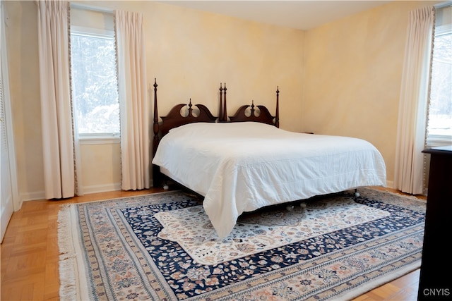 bedroom featuring light parquet flooring and multiple windows