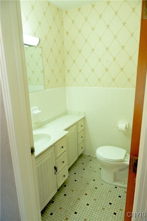 bathroom featuring tile walls, toilet, tile patterned floors, and vanity