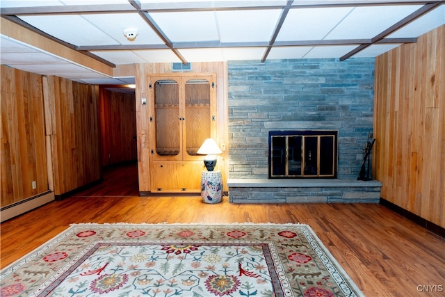 living room featuring wooden walls, a fireplace, and wood-type flooring