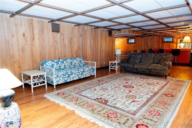 living room featuring hardwood / wood-style flooring, wooden walls, and coffered ceiling