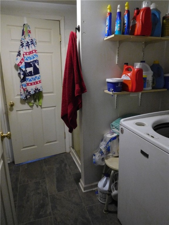 clothes washing area featuring washer / dryer and dark tile patterned flooring