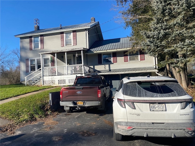 view of front of home featuring a garage, a front lawn, and a porch