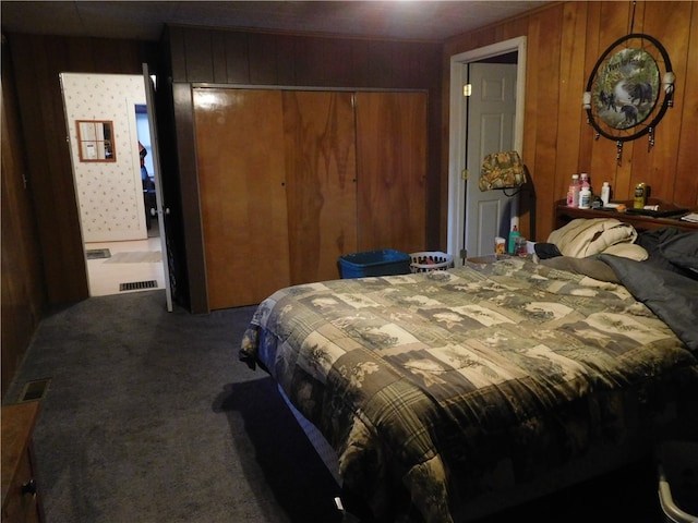 bedroom with carpet, wood walls, and a closet