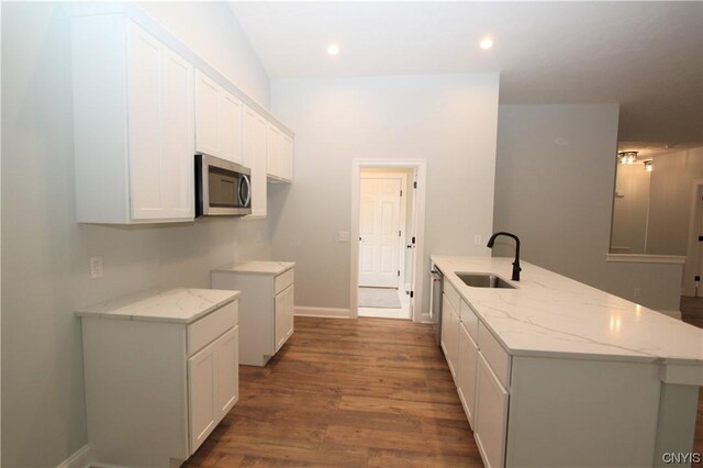 LOT214 Tall Tree Ln, Lysander, NY 13027 - kitchen featuring white cabinets, a sink, stainless steel microwave, light stone countertops, and a peninsula