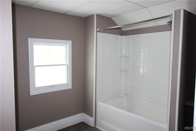 bathroom featuring bathing tub / shower combination and a drop ceiling