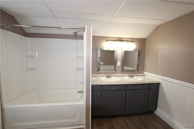 bathroom featuring large vanity, shower / bathtub combination, hardwood / wood-style flooring, and dual sinks