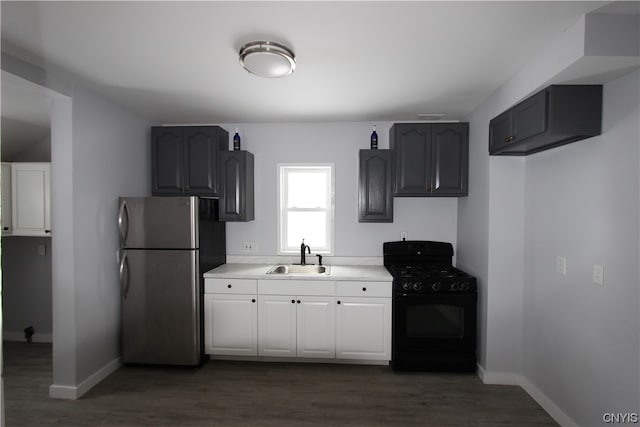 kitchen with sink, stainless steel refrigerator, dark wood-type flooring, and black range with gas stovetop