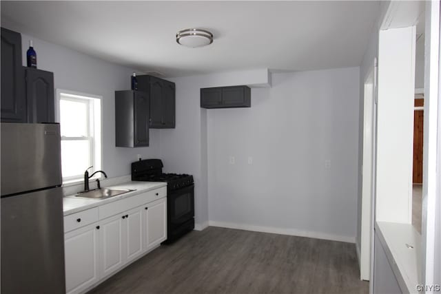 kitchen featuring dark hardwood / wood-style flooring, stainless steel refrigerator, white cabinets, black range with gas cooktop, and sink